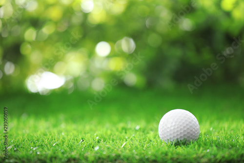 Golf ball on green grass against blurred background