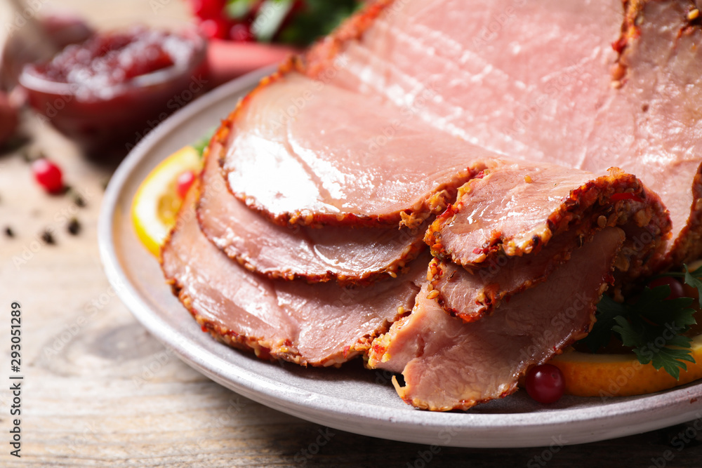 Delicious ham served with garnish on wooden table, closeup