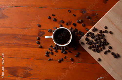 Coffee beans and cup on the tamble wood photo