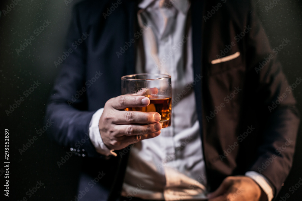 Closeup businessmen holding a glass of whiskey Closeup businessmen holding a glass of whiskey