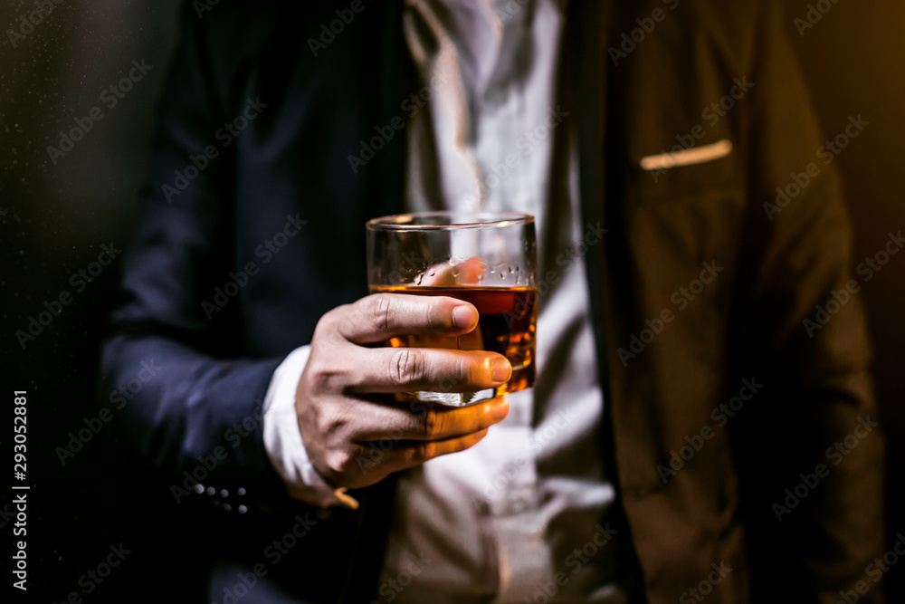 Closeup businessmen holding a glass of whiskey Closeup businessmen holding a glass of whiskey