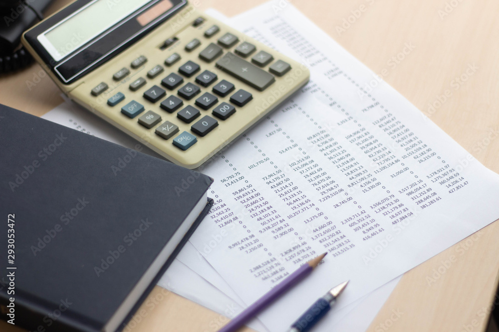 Financial accounting report on table with book and calculator Financial accounting report on table with book and calculator