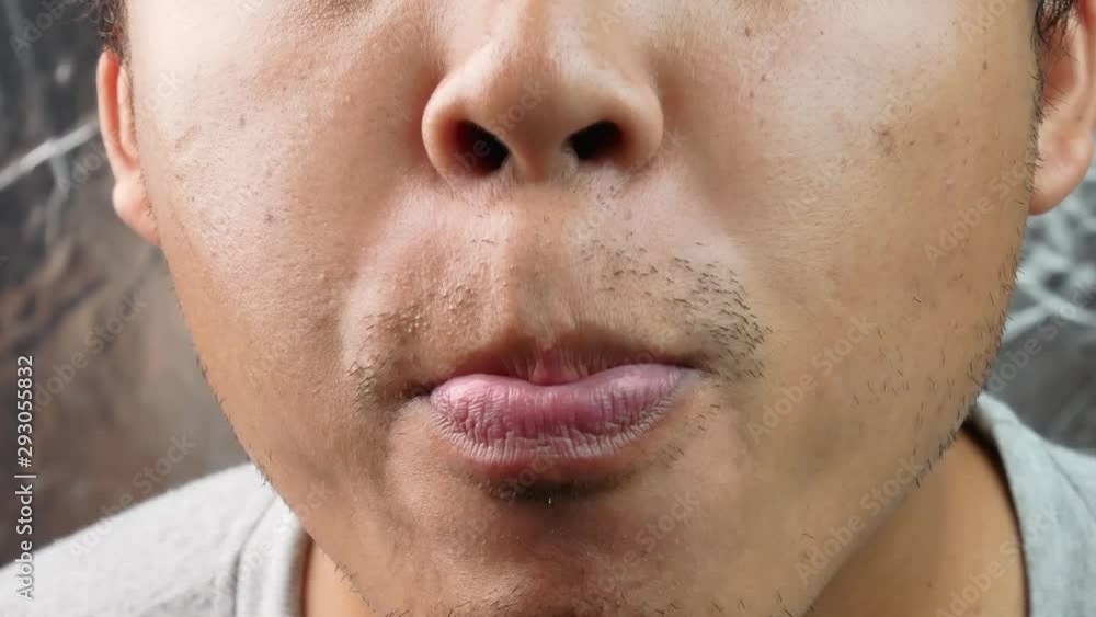 Asian middle aged man making fast tongue out over gray background. Asian middle aged man making fast tongue out over gray background.