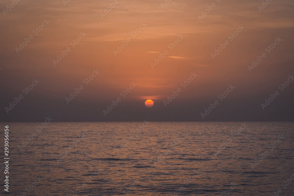Dramatic sunset over the ocean , Golden sunrise sunset over the sea ocean waves, Magnificent View Bright Horizon, uae beach , variety of colors and hues of the rising sun