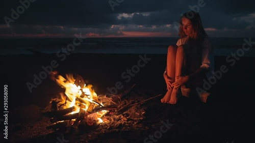 Hipster young woman in stylish clothes on the empty black sand tropical beach.