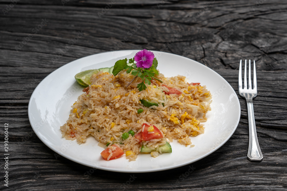 Fried rice with shrimps and vegetables in a white dish on an old wooden table, close up . Thai food , Thai cuisine Fried rice with shrimps and vegetables in a white dish on an old wooden table, close up . Thai food , Thai cuisine