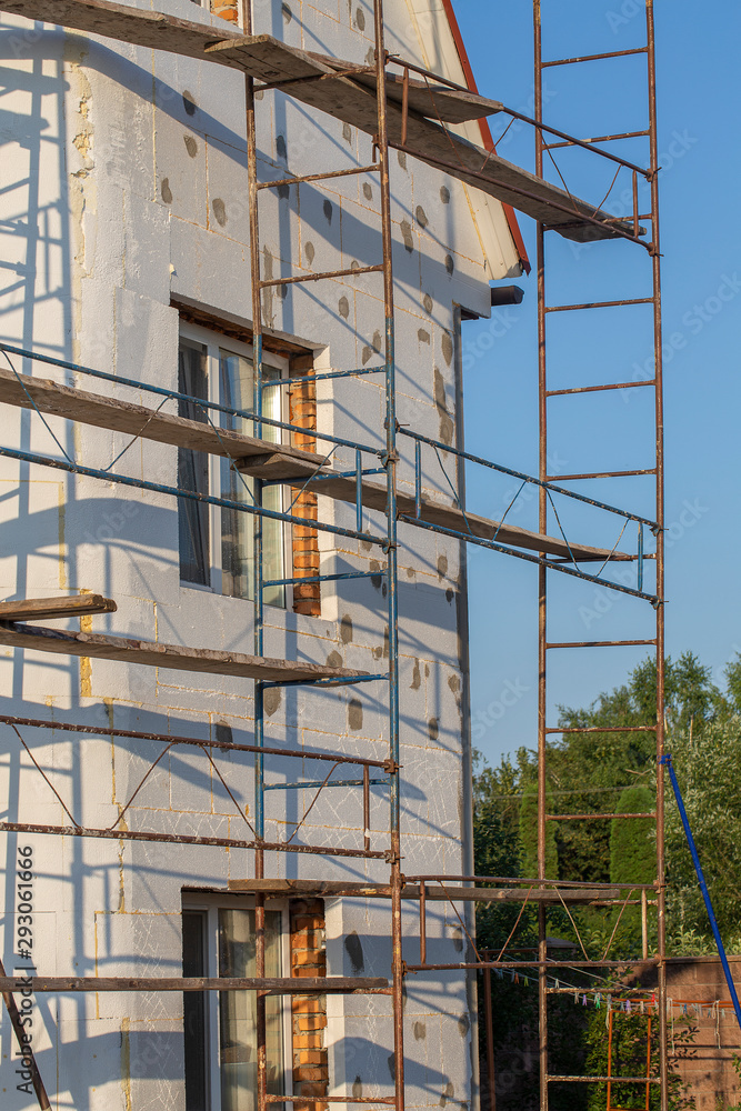 Scaffold on house, renovation. House for renovation with the scaffolding for workers on building