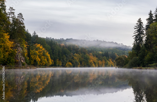 Amazing misty fog on Vltava river with autumn foliage