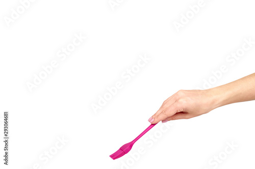 Hand with pink culinary brush, kitchen utensil.
