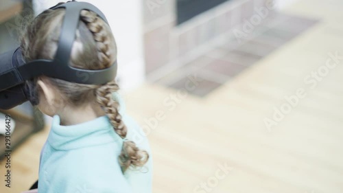 Little girl playing VR kids game in the living room.