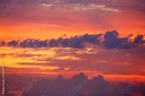 Hermoso cielo con nubes al amanecer con colores vivos, rojos y anaranjados.