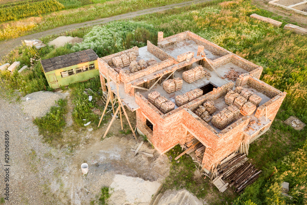 Aerial view of building site for future house, brick basement floor and stacks of brick for construction.