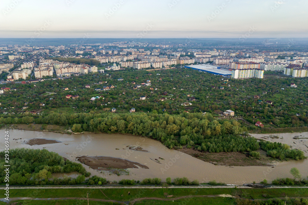 Aerial view of Ivano-Frankivsk city with residential area and suburb houses with a river in middle.