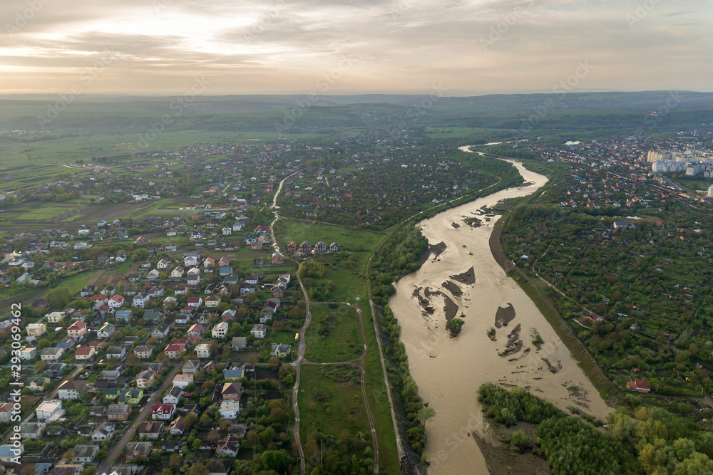 Aerial view of Ivano-Frankivsk city with residential area and suburb houses with a river in middle.