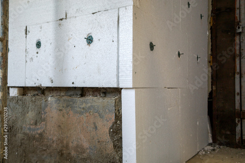 Insulation work of house walls with styrofoam sheets. © bilanol