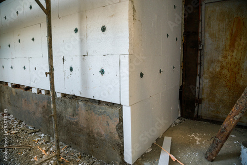Insulation work of house walls with styrofoam sheets.