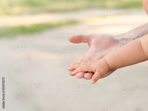 little baby hand with father's hand on light background with copy space © Nastya