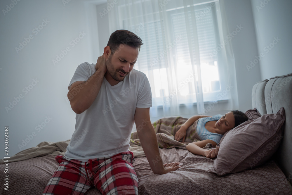 Man is waking up in the morning. He is having pain in neck. Man is waking up in the morning. He is having pain in neck.