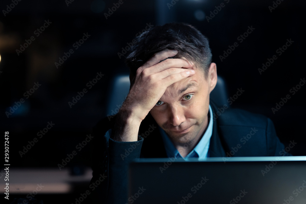 Stressed businessman working in the office in the late night during overtime period. Deadline concept.and overwork Stressed businessman working in the office in the late night during overtime period. Deadline concept.and overwork