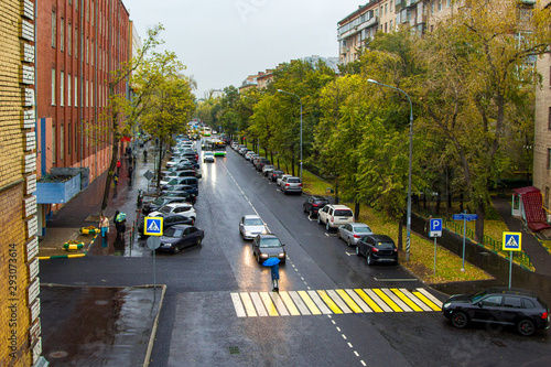 calm city street with cars and pedestrians in rain © hdmphoto