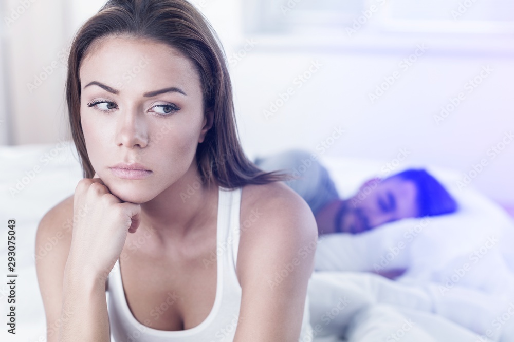 Dissatisfied beautiful young woman in bed with sad expression on her face, sex problems in long relationship or marriage while man sleeping. Saturation or satiety between caucasian couple, disinterest Dissatisfied beautiful young woman in bed with sad expression on her face, sex problems in long relationship or marriage while man sleeping. Saturation or satiety between caucasian couple, disinterest