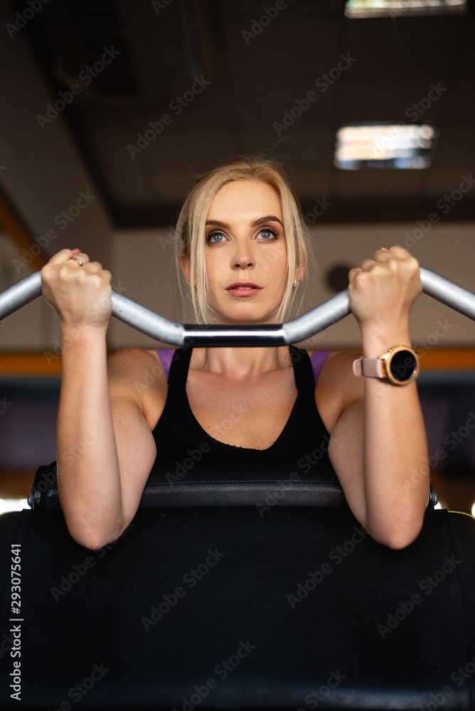 a young girl in the sports hall is engaged, strong hands lift the barbell with weight, a focused look a young girl in the sports hall is engaged, strong hands lift the barbell with weight, a focused look