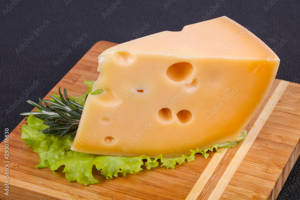 Maasdam cheese in the board served salad leaves Maasdam cheese in the board served salad leaves
