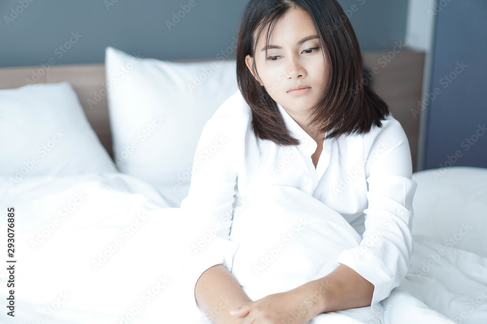 Closeup woman sitting on bed in the bedroom with thinking or depressed feeling, selective focus Closeup woman sitting on bed in the bedroom with thinking or depressed feeling, selective focus