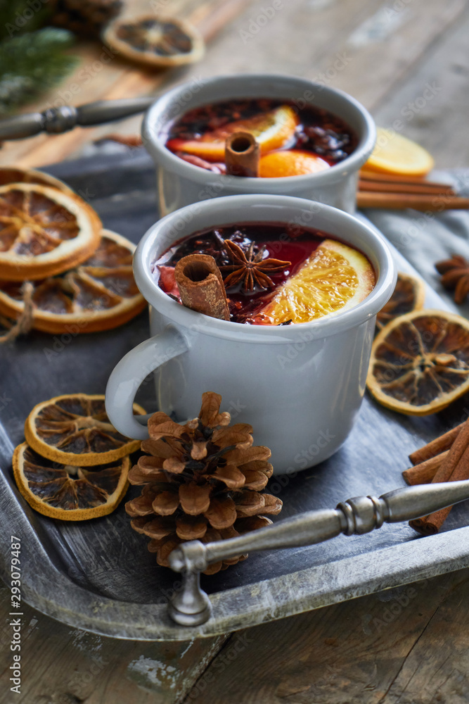 Mulled wine in two gray metall mugs with orange and spices Rustic style On wooden background Mulled wine in two gray metall mugs with orange and spices Rustic style On wooden background
