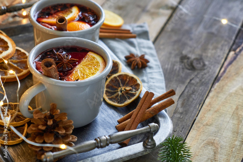 Bilde på lerret Christmas hot mulled wine in two rustic mugs with fruits and spices