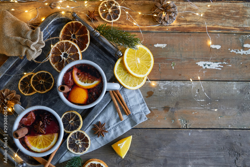 Christmas mulled wine in two rustic mugs with fruits and spices on wooden background Christmas mulled wine in two rustic mugs with fruits and spices on wooden background
