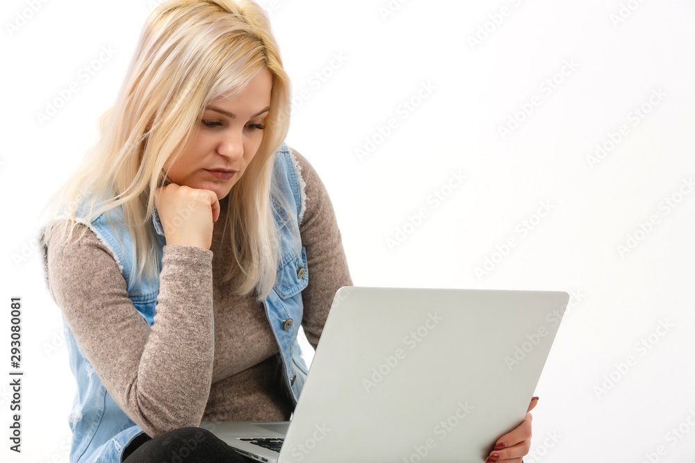 Young woman with laptop sitting on floor near light wall Young woman with laptop sitting on floor near light wall