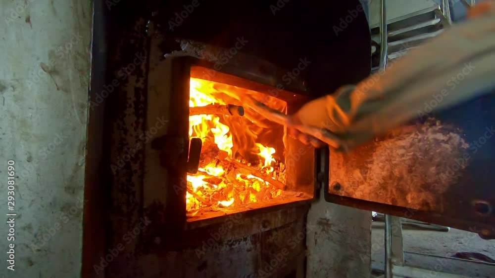 slow motion man throwing wood into a furnace 3 slow motion man throwing wood into a furnace 3