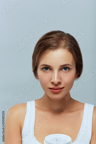 Skin care. Beauty Concept. Young Beautiful  woman holding cosmetic cream. Woman applying moisturizing cream.