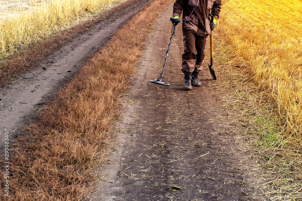 Fototapeta premium a man with a metal detector in search of a treasure