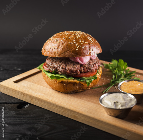 Tasty cheeseburger on a wooden board ready to be served