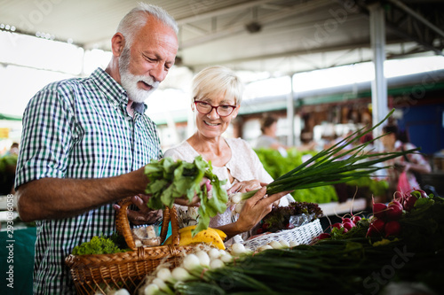 Mature couple shopping vegetables and fruits on the market. Healthy diet.