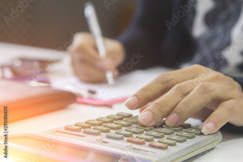 Woman using calculator with doing Accounting for family expenses. at home office.