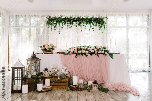 Beautiful groom and bride table near large light windows decorated with natural materials photo