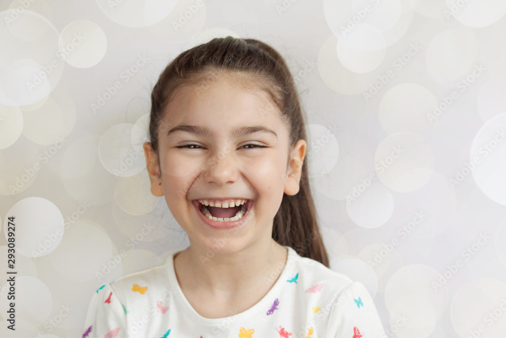 Portrait of happy adorable laughing child girl on light background. Positive emotions. Portrait of happy adorable laughing child girl on light background. Positive emotions.