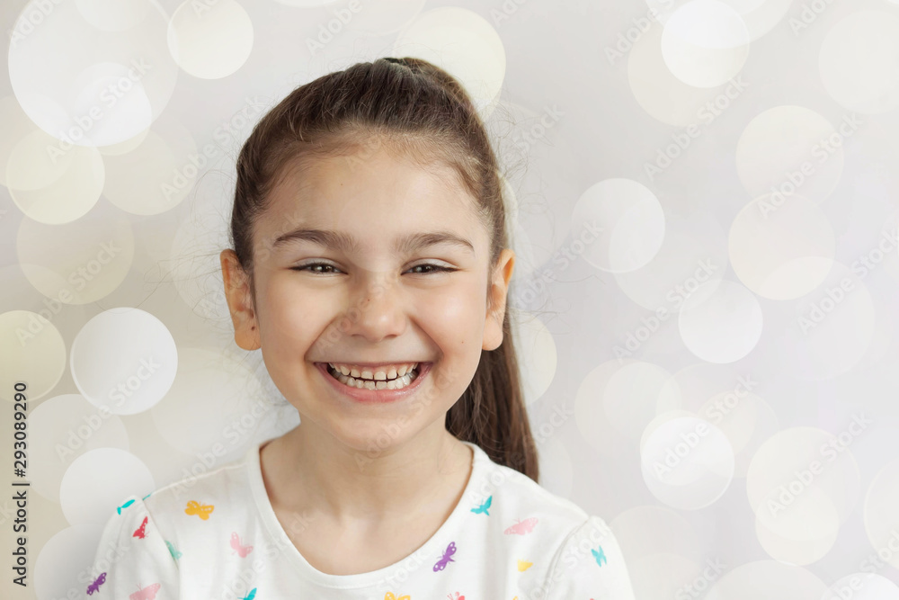 Portrait of happy adorable laughing child girl on light background. Positive emotions. Portrait of happy adorable laughing child girl on light background. Positive emotions.