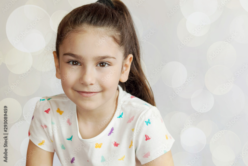 Portrait of happy smiling child girl on light background. Positive emotions. Portrait of happy smiling child girl on light background. Positive emotions.