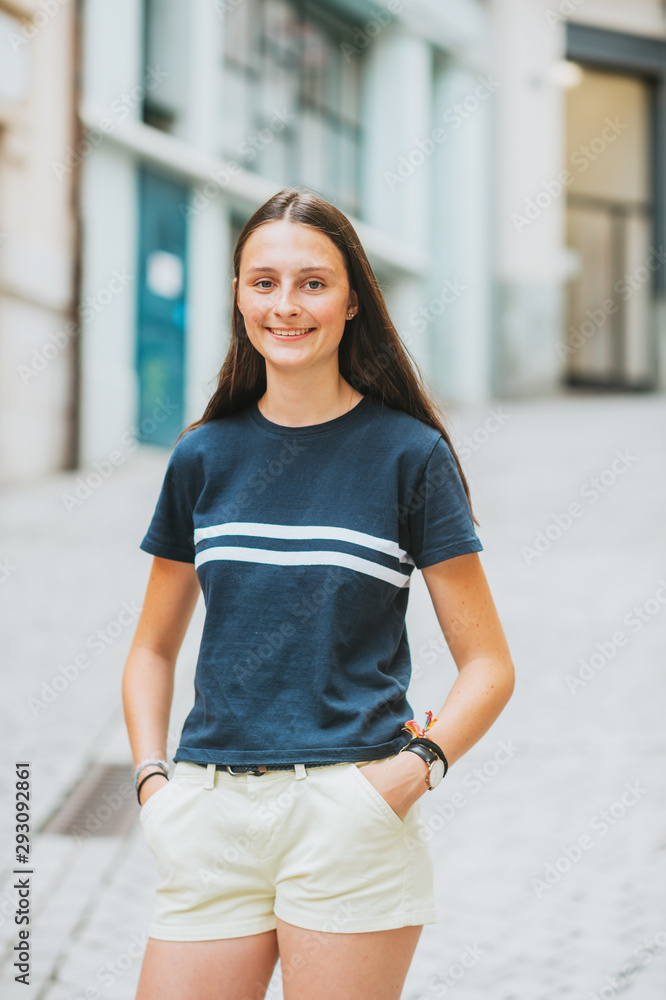 Outdoor portrait of pretty teenage girl on the city street
