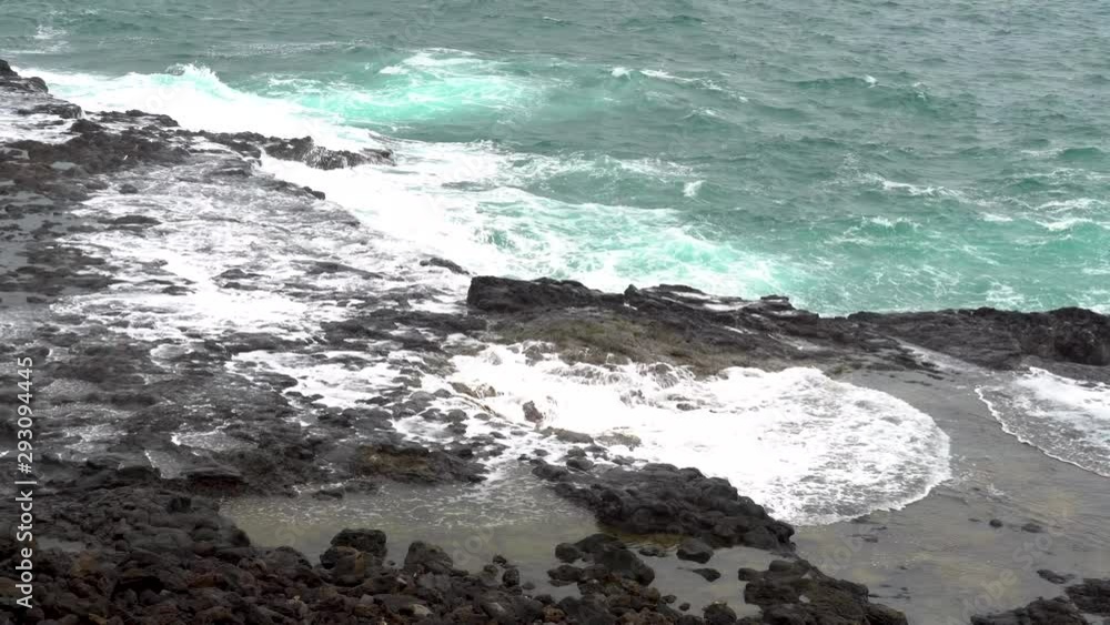 Water from Pacific Ocean shoots out of blowhole along rocky coast of Kaui. Water from Pacific Ocean shoots out of blowhole along rocky coast of Kaui.
