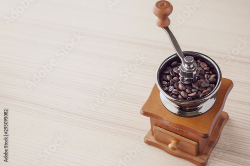 Vintage manual coffee grinder with roasted coffee beans