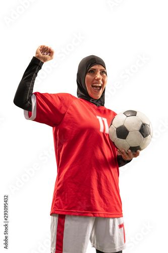 Female muslim soccer player in hijab standing with a ball on a white background.