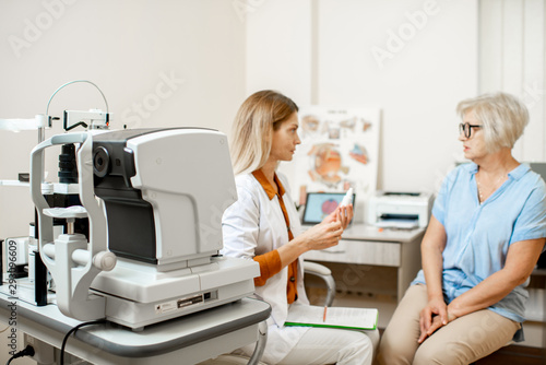 Senior woman patient talking with female ophthalmologist during a medical consultation at the ophthalmologic office