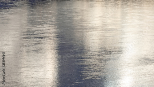 The reflection on the river during sunset, tinny ripples and beautiful metal lights.