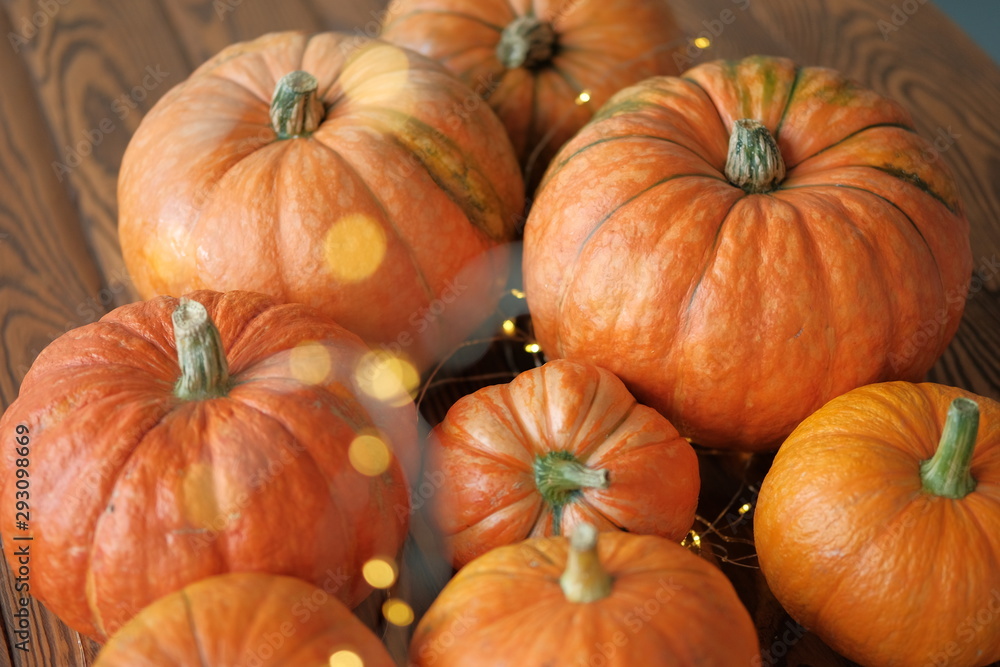 Obraz premium pumpkins with a shining garland on a wooden table