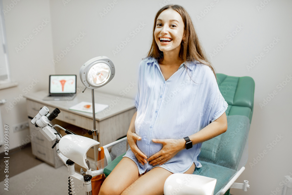 Smiling Pregnant Woman Sitting On The Gynecological Chair Before A Medical Examination By A 